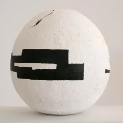 White Cement Sphere with Black Geometric Insertions